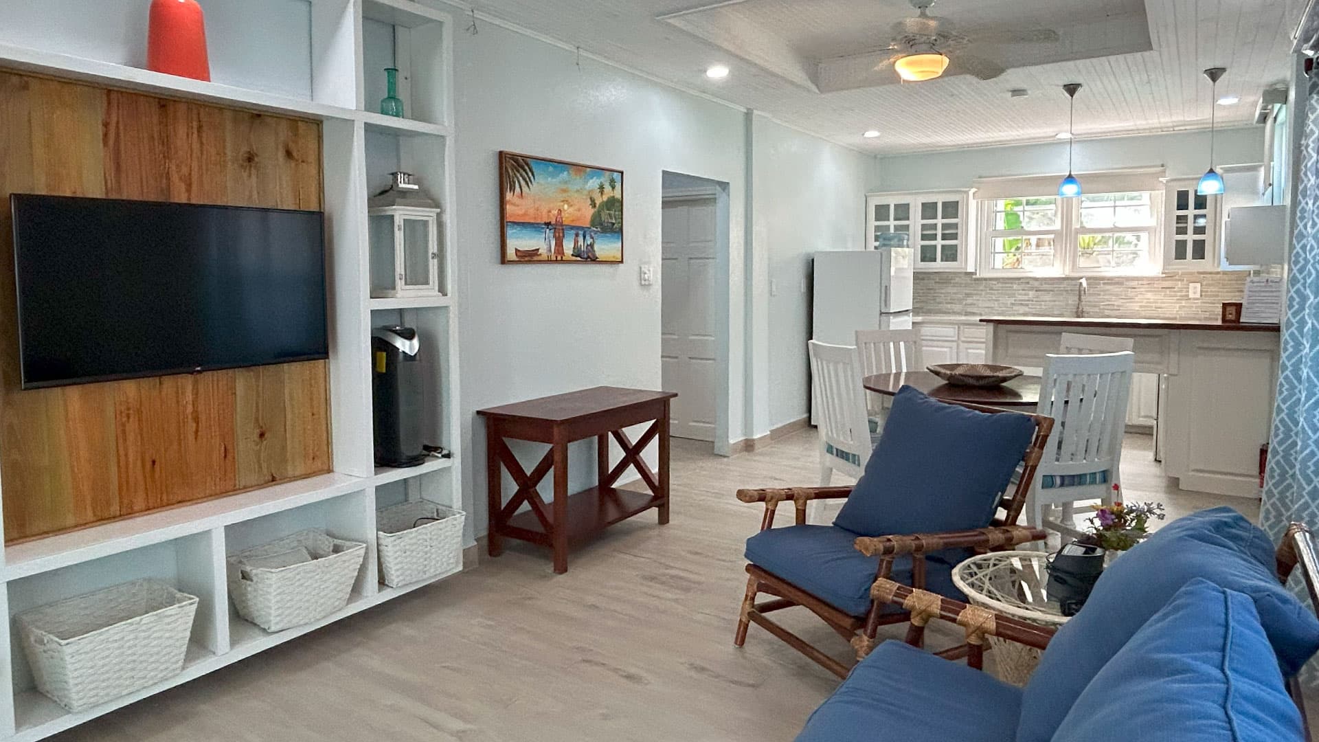 A bright, modern living space featuring a TV, dining table, and comfortable seating.